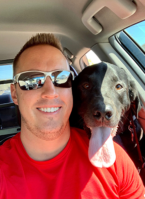 Josh Butcher in the car with his dog Yadi, his favorite companion.