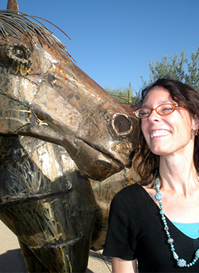 Keri Miller standing next to metal horse sculpture